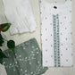 White shirt with green embroidery and green fabric with white patterns on a light background